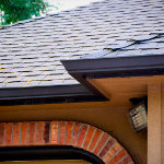 Seamless molded residential gutter wrapping around a house in a Z or lighting bolt shape