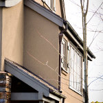 Custom fitting dark brown residential gutter and downspout for a multi level house